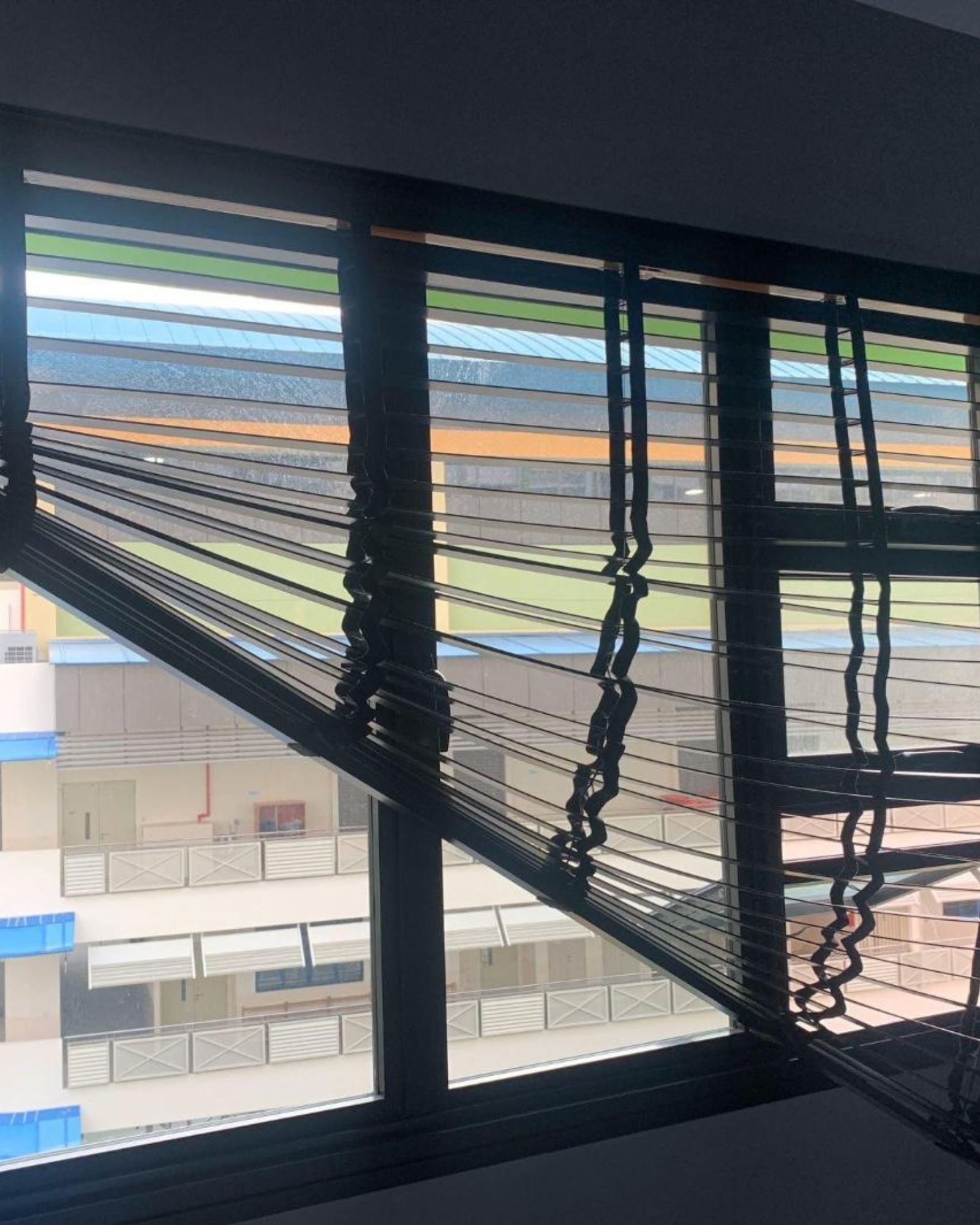 Korean blind slats collapsed and tangled at a Singapore HDB window