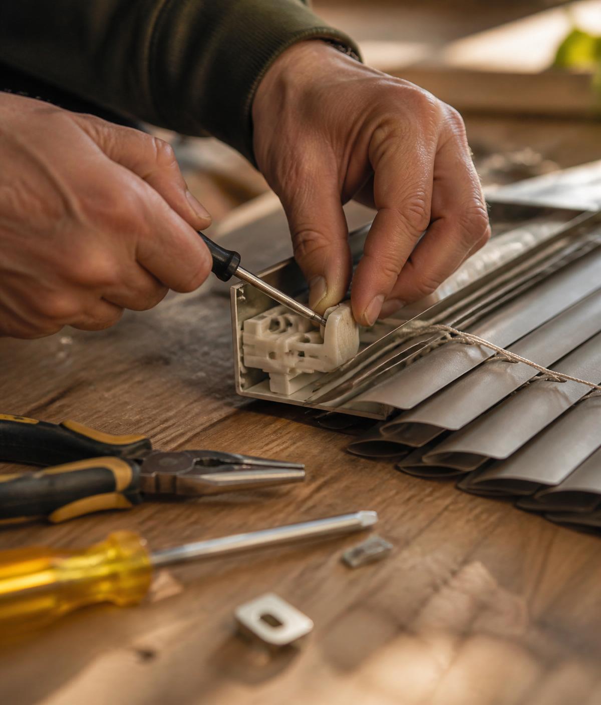 Craftsman repairing a venetian blind headrail